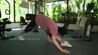 Woman is doing warming up and stretching in the gym before intense workout
